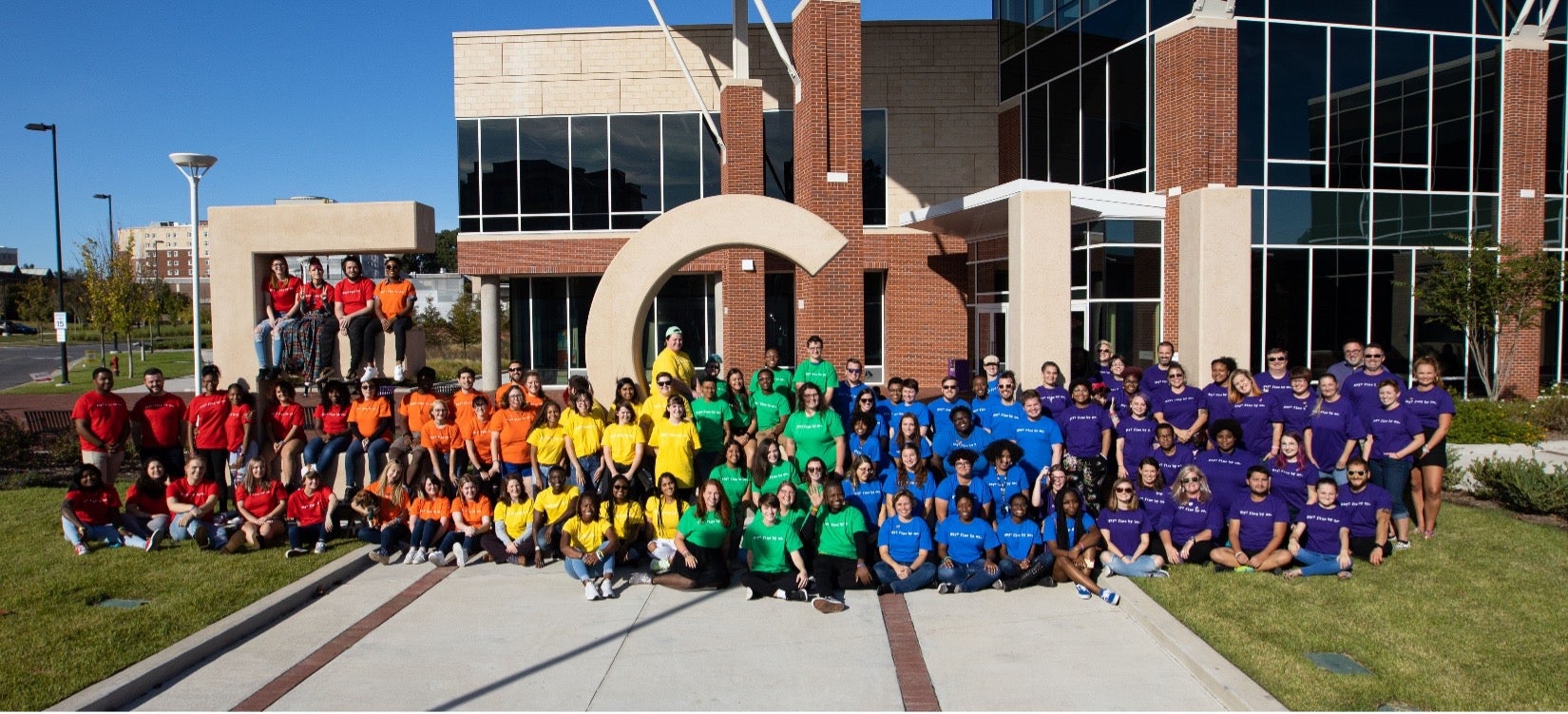 Students in rainbow colored shirts standing outside Main Campus Student Center