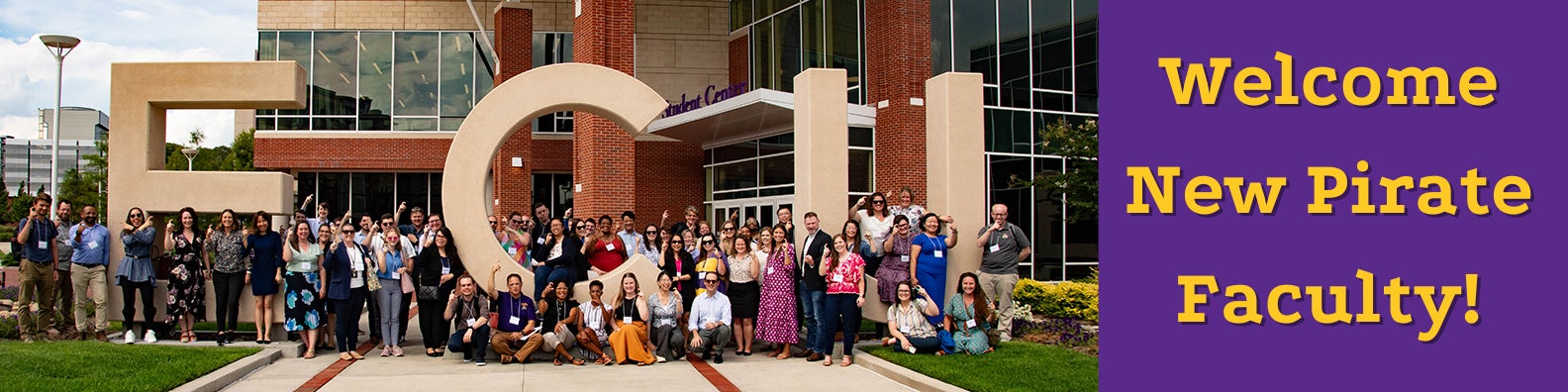 The group photo of all attendees of New Faculty Orientation 2023 posing with the large ECU by the Main Campus Student Center